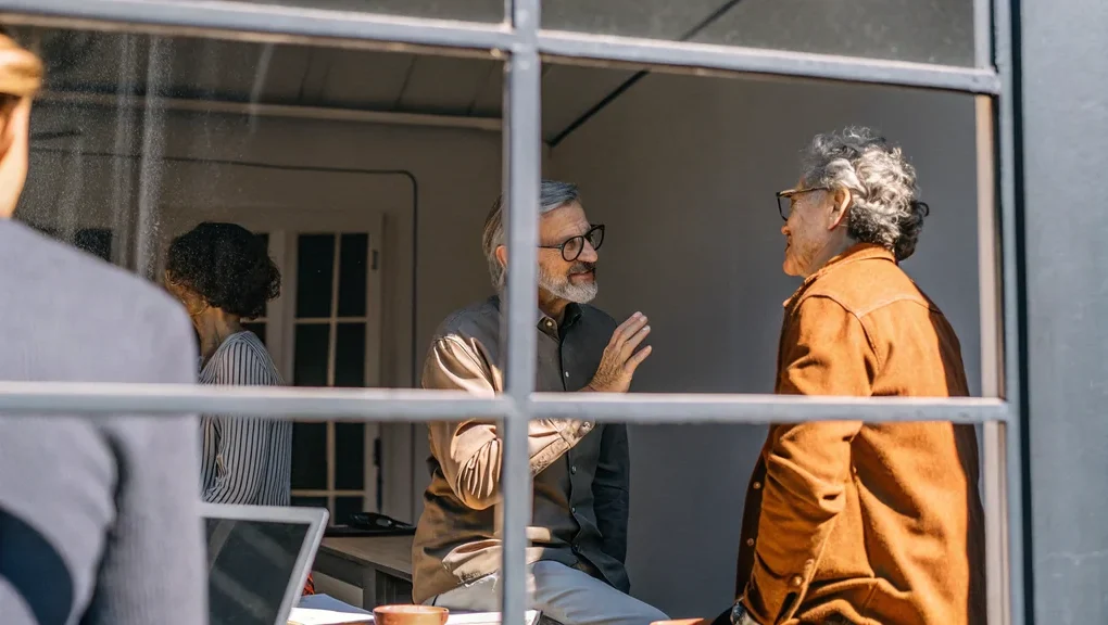Executives having a difficult conversation in a glass-walled office